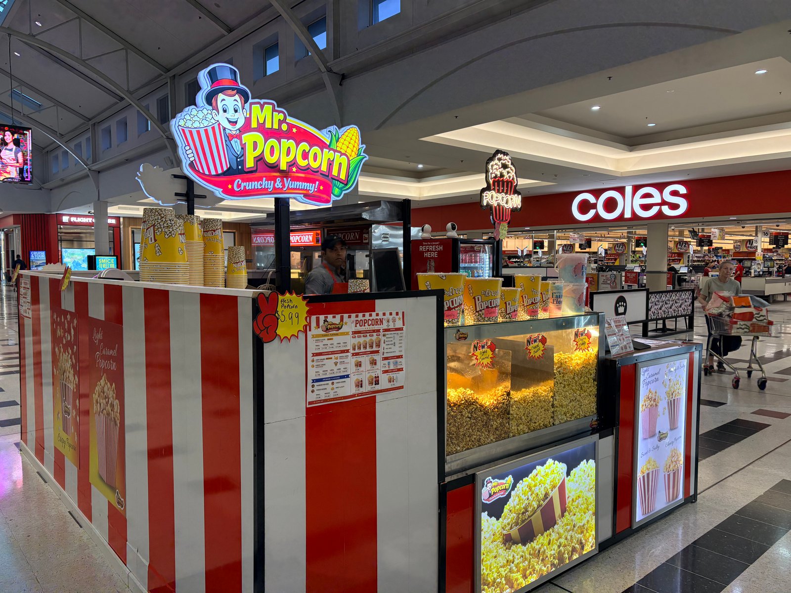 Mr. Popcorn mascot holding a bucket of popcorn
